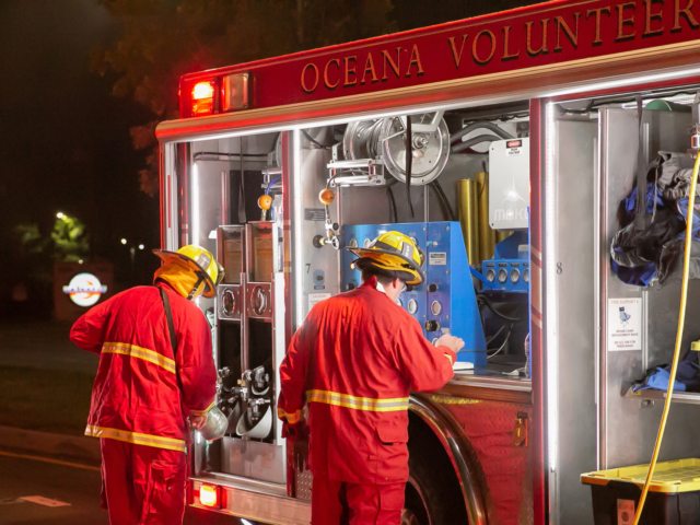 Two firefighters checking equipment in truck at night