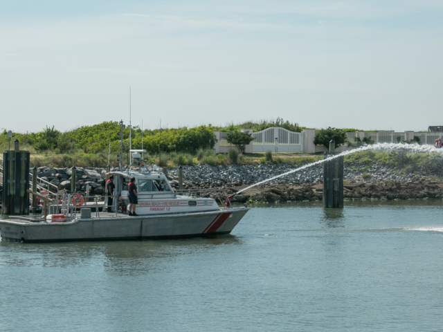 Fire boat with water cannon spraying water in Rudee Inlet