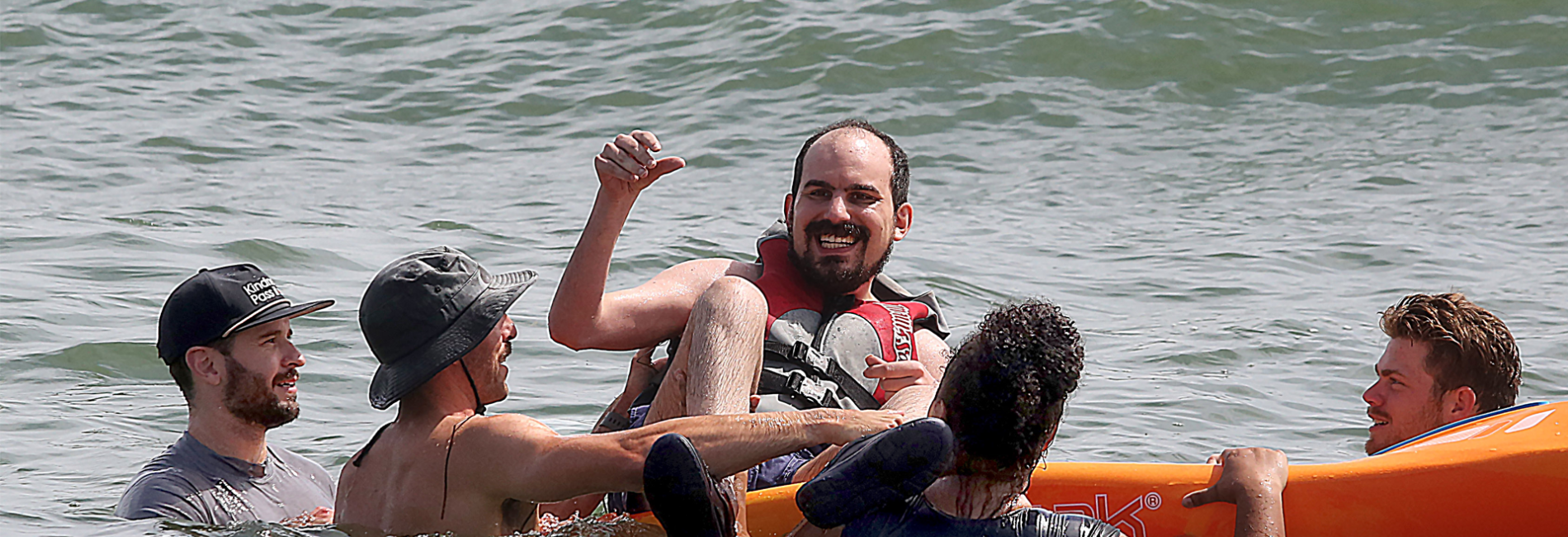 Group of youth swimming in body of water